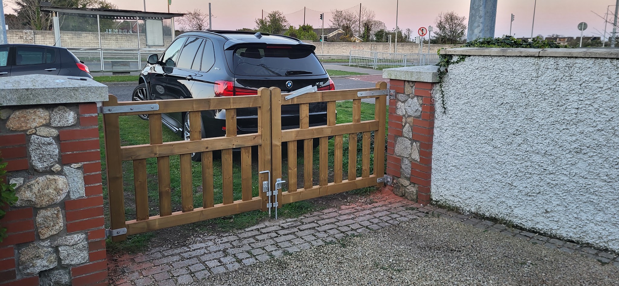 Timber garden gate between brick pillars